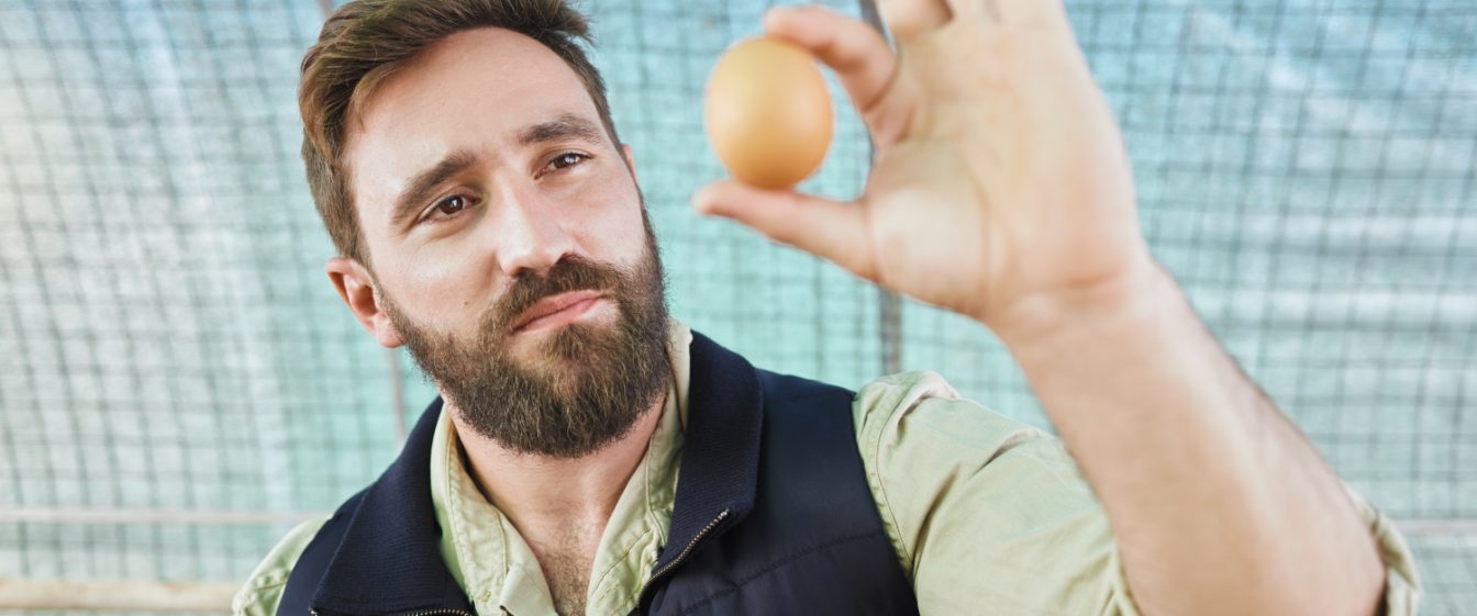 Man examining an egg